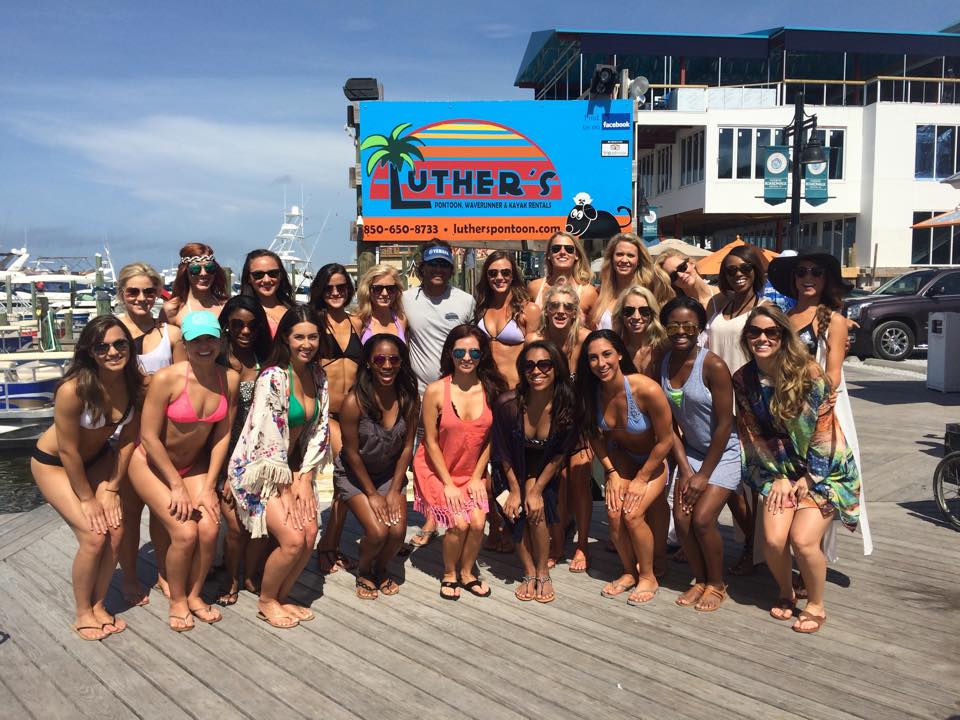 A large group of guests posing on the boardwalk in front of the Luther's sign