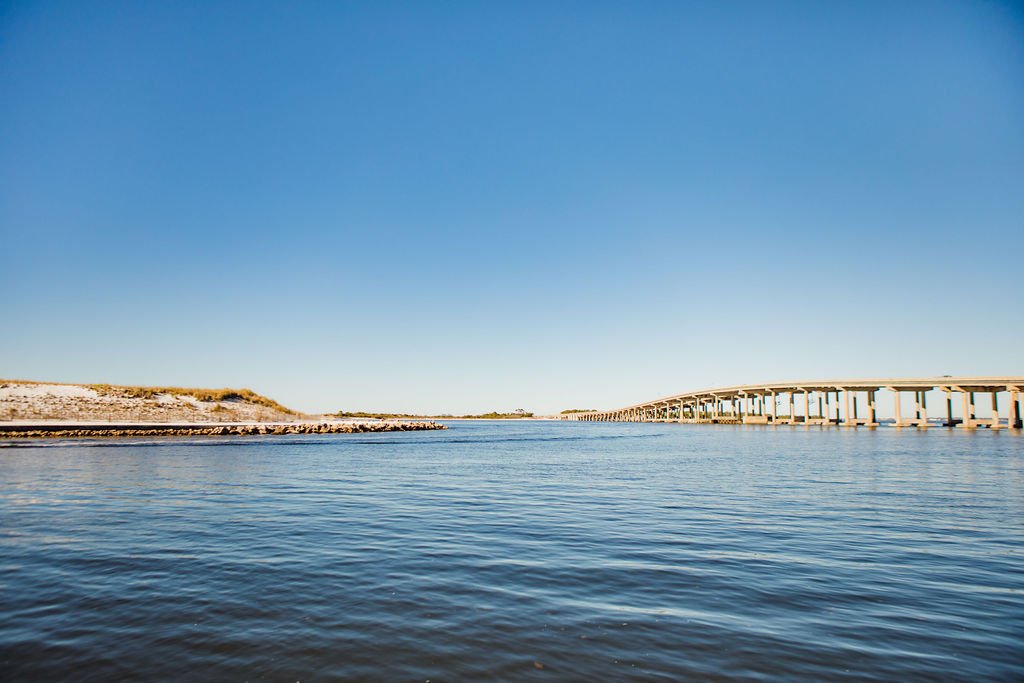 Calm water on the bay with a bridge on the horizon